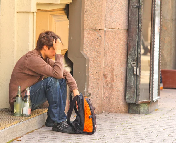 Kaldırımda yalnız oturan üzgün bir sarhoş adam — Stok fotoğraf