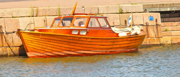 Błyszczący drewniane łódź, cumowanie w wodzie w harbor — Zdjęcie stockowe