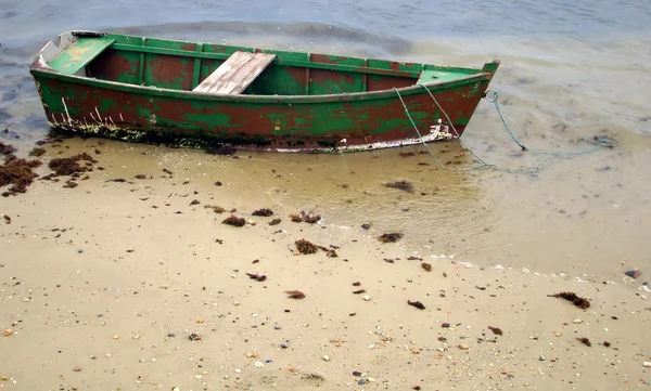 Pequeño bote de madera anclado en la playa — Foto de Stock