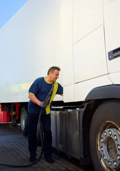 Bestuurder bij het benzinestation uitvoeren door de vrachtwagen — Stockfoto