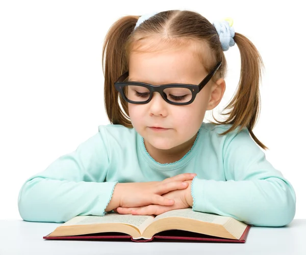 Dziewczynka czytamy książkę podczas noszenia okularów — Zdjęcie stockowe