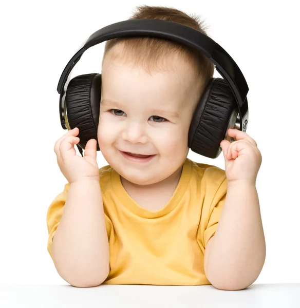 Cute little boy enjoying music using headphones — Stock Photo, Image