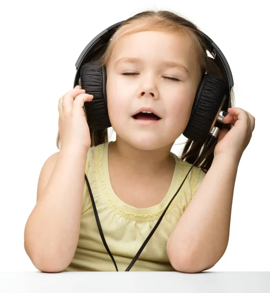 Nettes kleines Mädchen genießt Musik mit Kopfhörern — Stockfoto