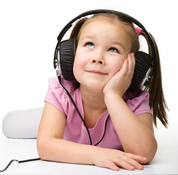 Cute little girl enjoying music using headphones — Stock Photo, Image