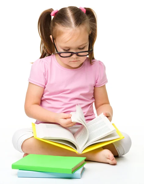 Χαριτωμένο κοριτσάκι διαβάζει ένα βιβλίο — Φωτογραφία Αρχείου