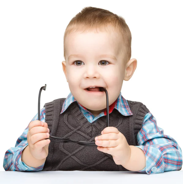 Schattig klein kind bijten bril — Stockfoto
