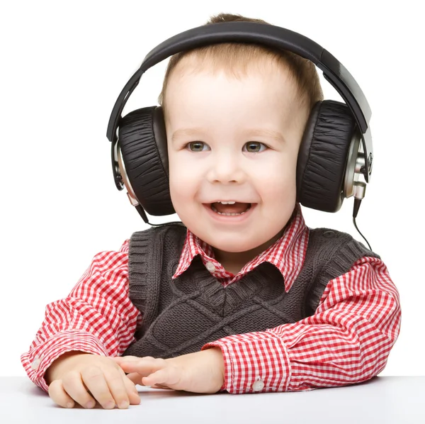 Bonito menino gostando de música usando fones de ouvido — Fotografia de Stock