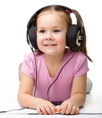 Kulaklık takıp müzik dinlemekten hoşlanan tatlı küçük kız.