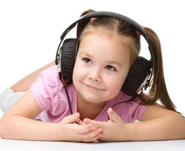 Gadis kecil yang lucu menikmati musik menggunakan headphone — Stok Foto