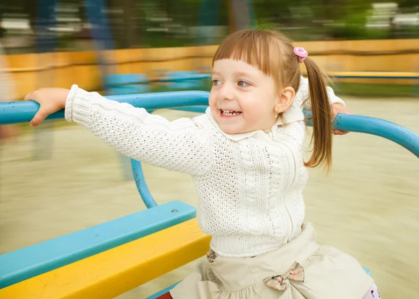 Menina bonito está montando alegre-go-round — Fotografia de Stock