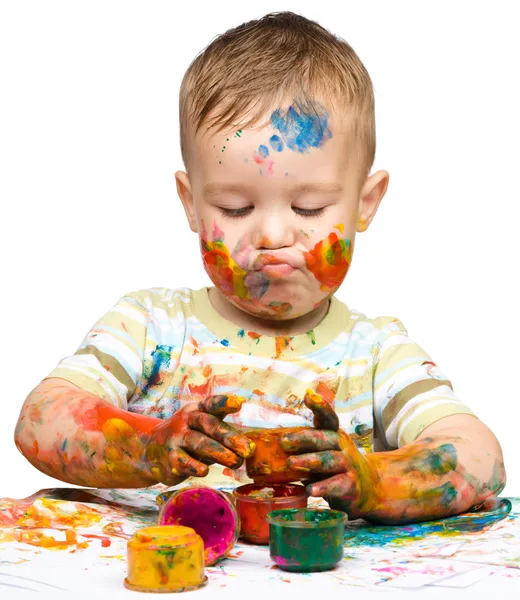 小さな男の子は塗料で遊んでいます。 — ストック写真