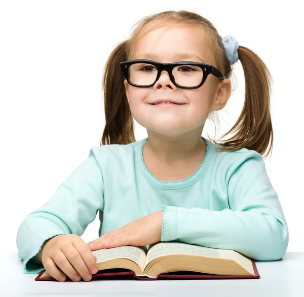 Happy little girl with book wearing black glasses — Stock Photo, Image