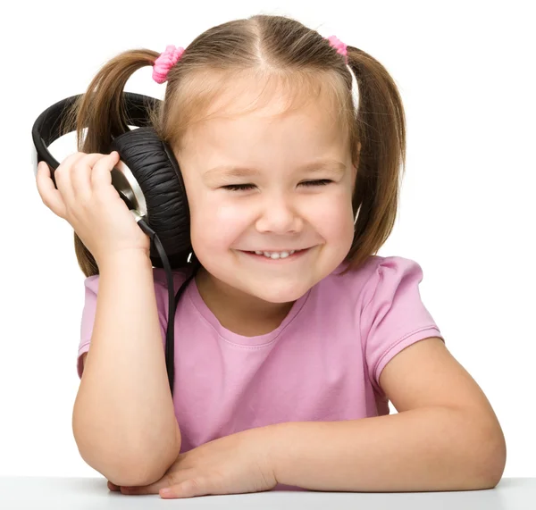 Cute little girl enjoying music using headphones Royalty Free Stock Images