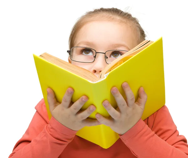 Klein meisje droomt tijdens het lezen van boek — Stockfoto