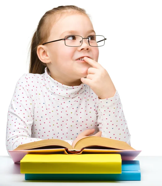 Aranyos kis lány álmodik a könyv olvasása közben — Stock Fotó