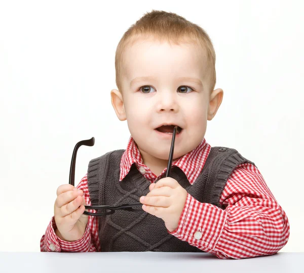 Милый маленький ребенок кусает очки — стоковое фото