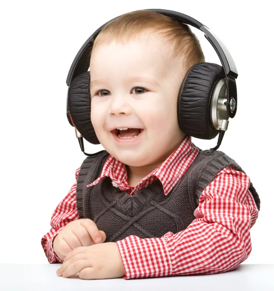 Bonito menino gostando de música usando fones de ouvido — Fotografia de Stock