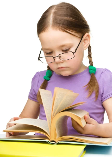 Linda niña leyendo libro con gafas — Foto de Stock