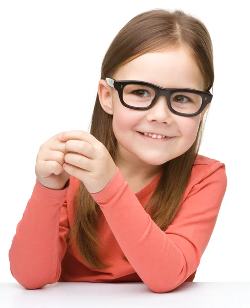 Happy little girl sits at a table and smile — Stock Photo, Image