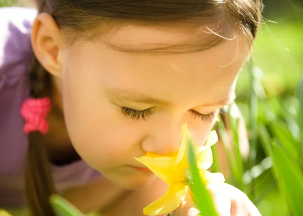 Retrato de una linda niña oliendo flores — Foto de Stock