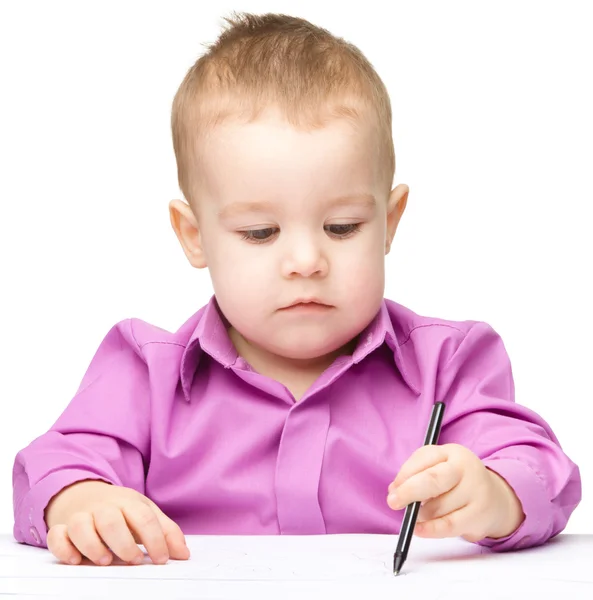 Schattige kleine jongen is tekenen met pen Rechtenvrije Stockfoto's