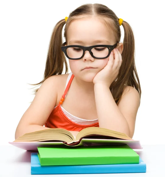 Cute little girl is reading book — Stock Photo, Image