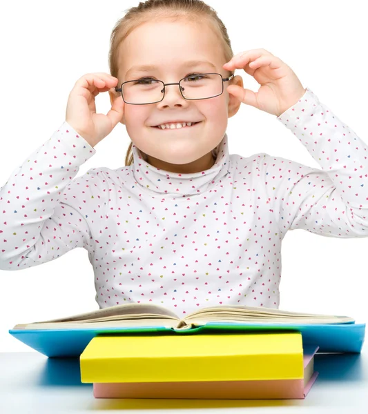 Милая веселая маленькая девочка читает книгу — стоковое фото