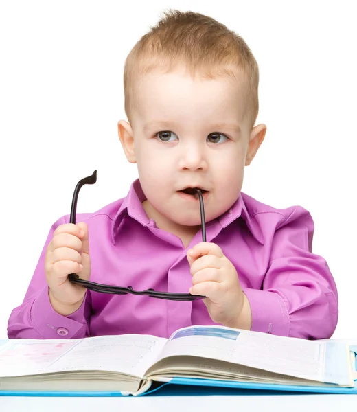 Niedliches kleines Kind spielt mit Buch — Stockfoto