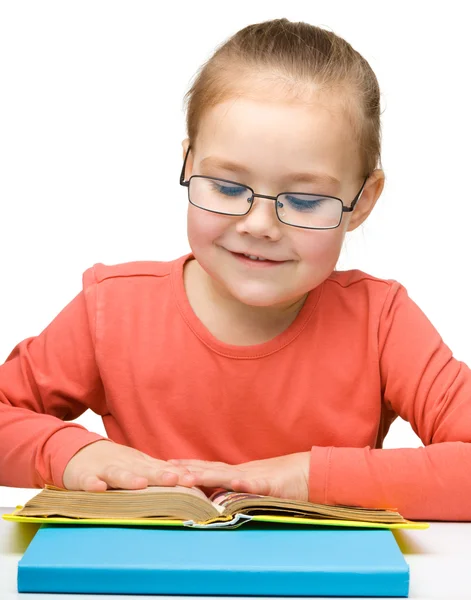 Милая веселая маленькая девочка читает книгу — стоковое фото