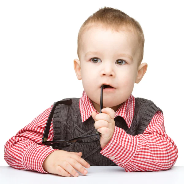 Niedliches kleines Kind beißt Brille — Stockfoto