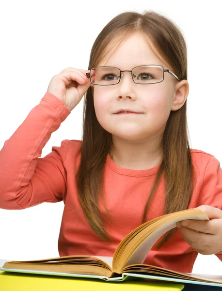 Cute little girl reading book wearing glasses — Stock Photo, Image