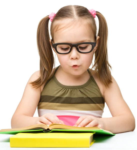 Cute little girl is reading book — Stock Photo, Image