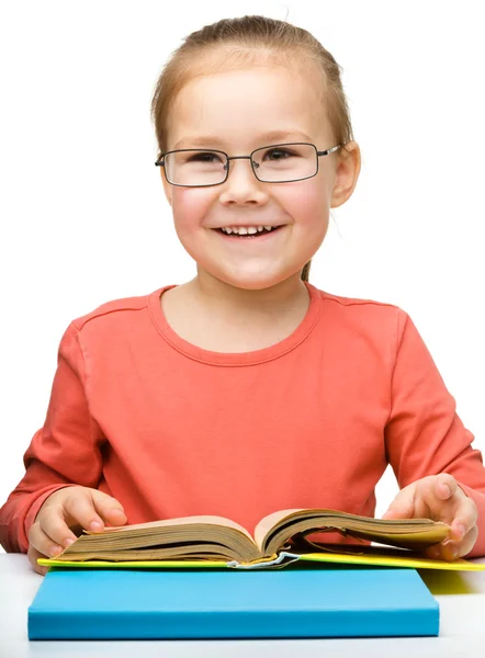 Мила весела дівчинка читає книгу — стокове фото