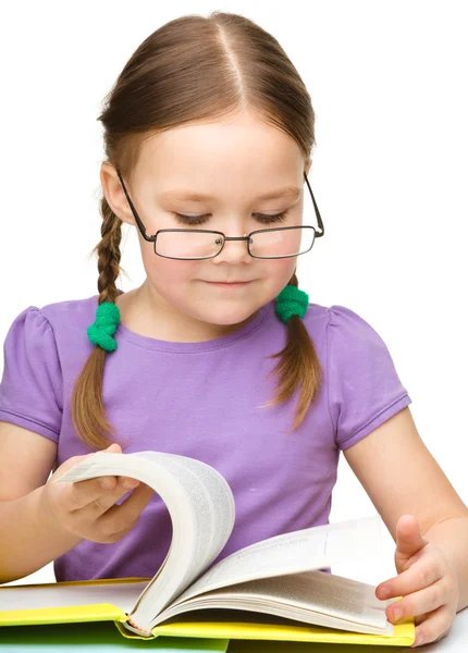 Nettes kleines Mädchen liest Buch mit Brille — Stockfoto