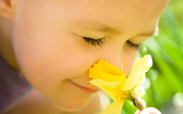 Porträt eines niedlichen kleinen Mädchens, das Blumen riecht — Stockfoto