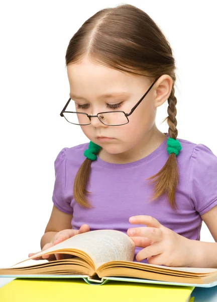 Söt liten flicka som läser bok glasögon — Stockfoto