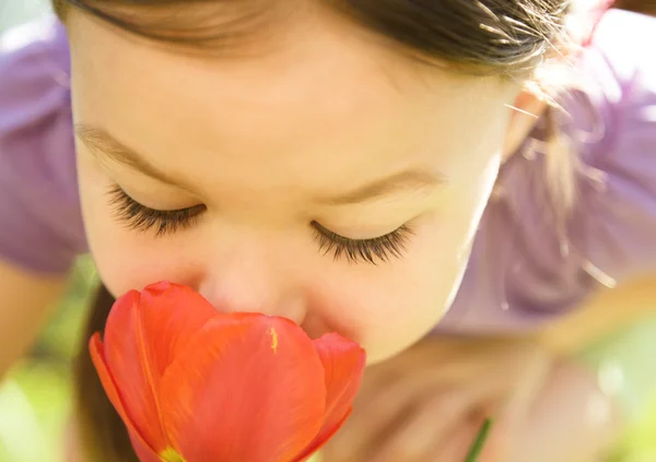 stock image Portrait of a cute little girl smelling flowers