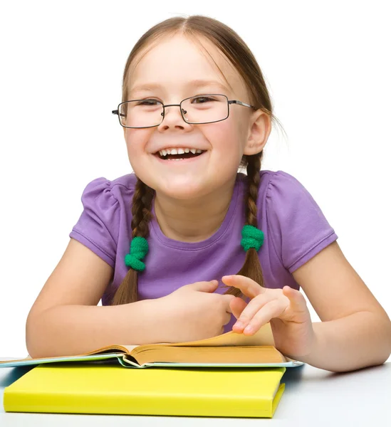 Cute cheerful little girl reading book Stock Picture