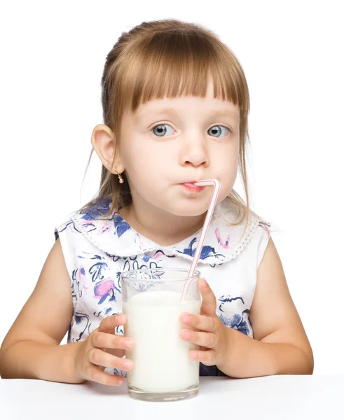 Cute little girl drinks milk using drinking straw — Stock Photo, Image