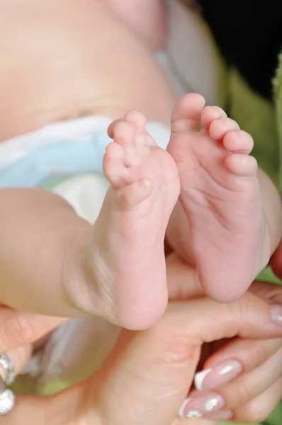 Pieds de bébé dans la main de maman — Photo