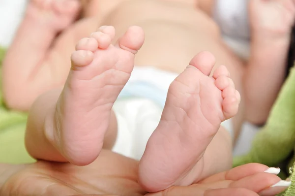 Детские ножки в маминой руке — стоковое фото