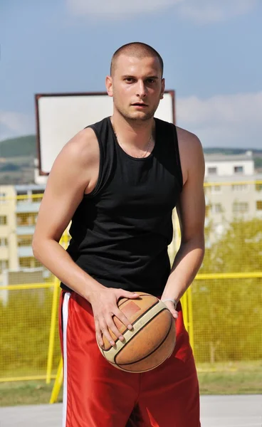 Jogador de basquete posando na frente do backboard — Fotografia de Stock