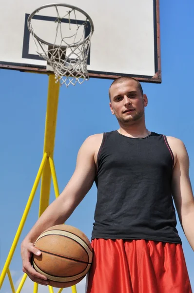 Jugador de baloncesto posando delante del tablero — Foto de Stock