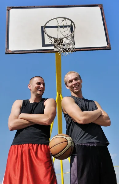Двое баскетболистов улыбаются на площадке — стоковое фото