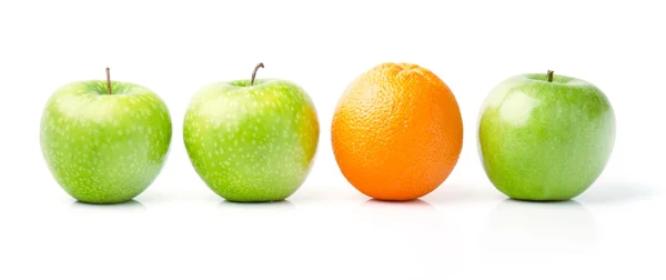 Naranja entre manzanas verdes — Foto de Stock
