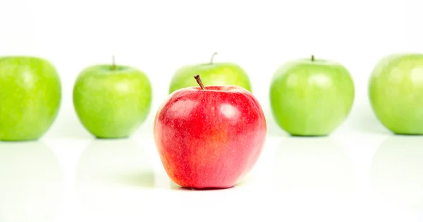 Rött äpple framför gröna äpplen — Stockfoto