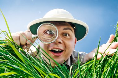 Young Man Looking through a Magnifying Glass clipart