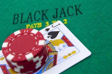 arka planda siyah jack ile kırmızı poker fişleri.