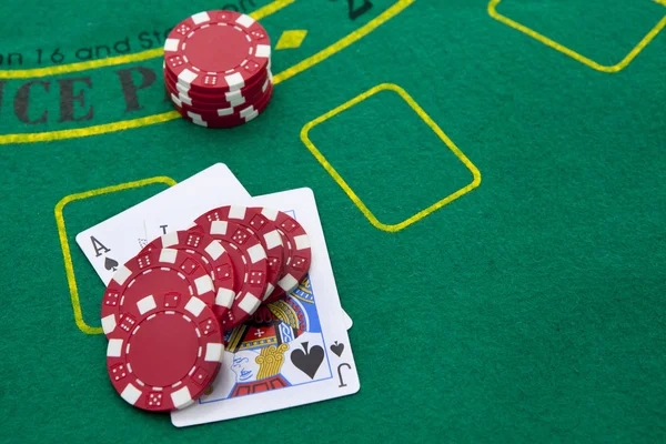 Пиковый туз и черный домкрат с красными фишками для покера в бэкгро — стоковое фото