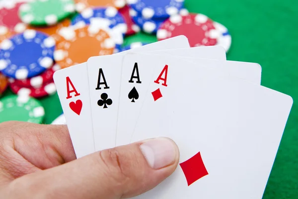 Poker, fyra ess holded i handen över ett kasino bord fullt med ch — Stockfoto